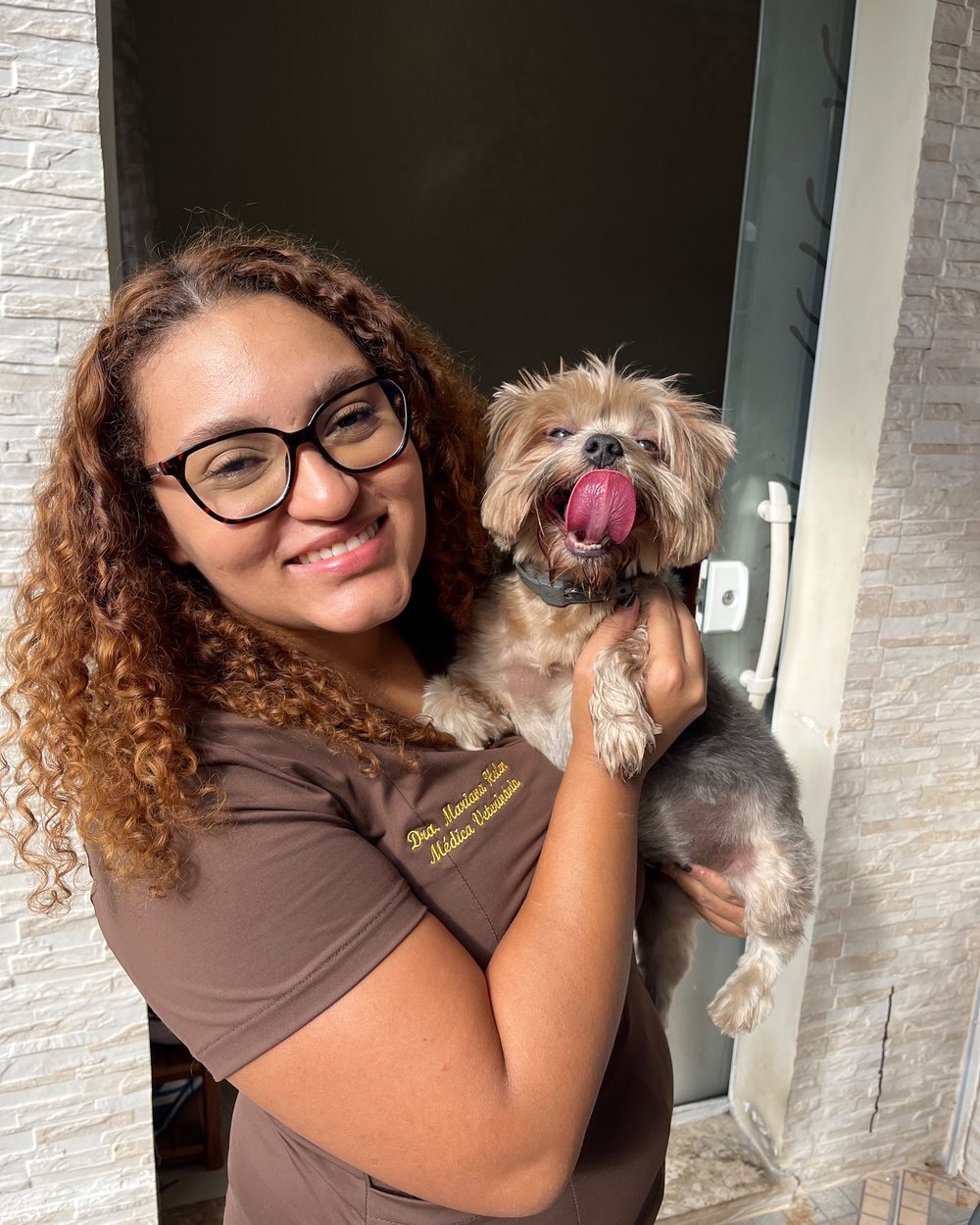 Dra. Mariana Helen, veterinária domiciliar no Rio de Janeiro, com a cadela Beth no colo durante atendimento em casa