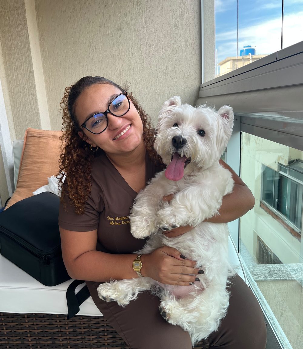 Dra. Mariana Helen, veterinária domiciliar, com o cão Scotch durante atendimento em casa