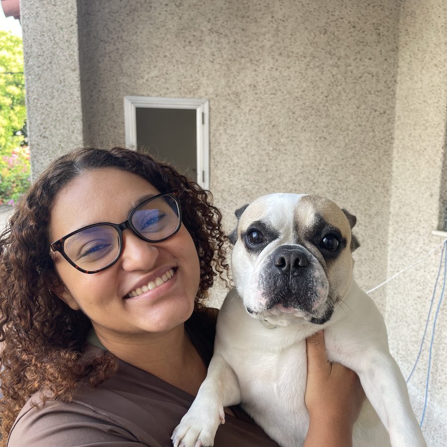 Dra. Mariana Helen com um buldogue no colo em atendimento domiciliar