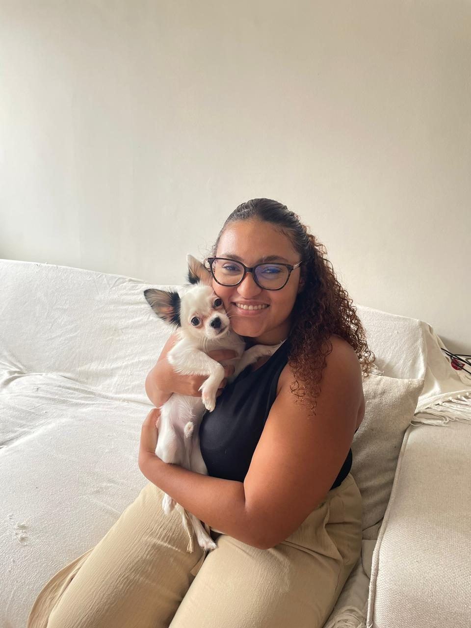 Dra. Mariana abraçando um chihuahua em atendimento