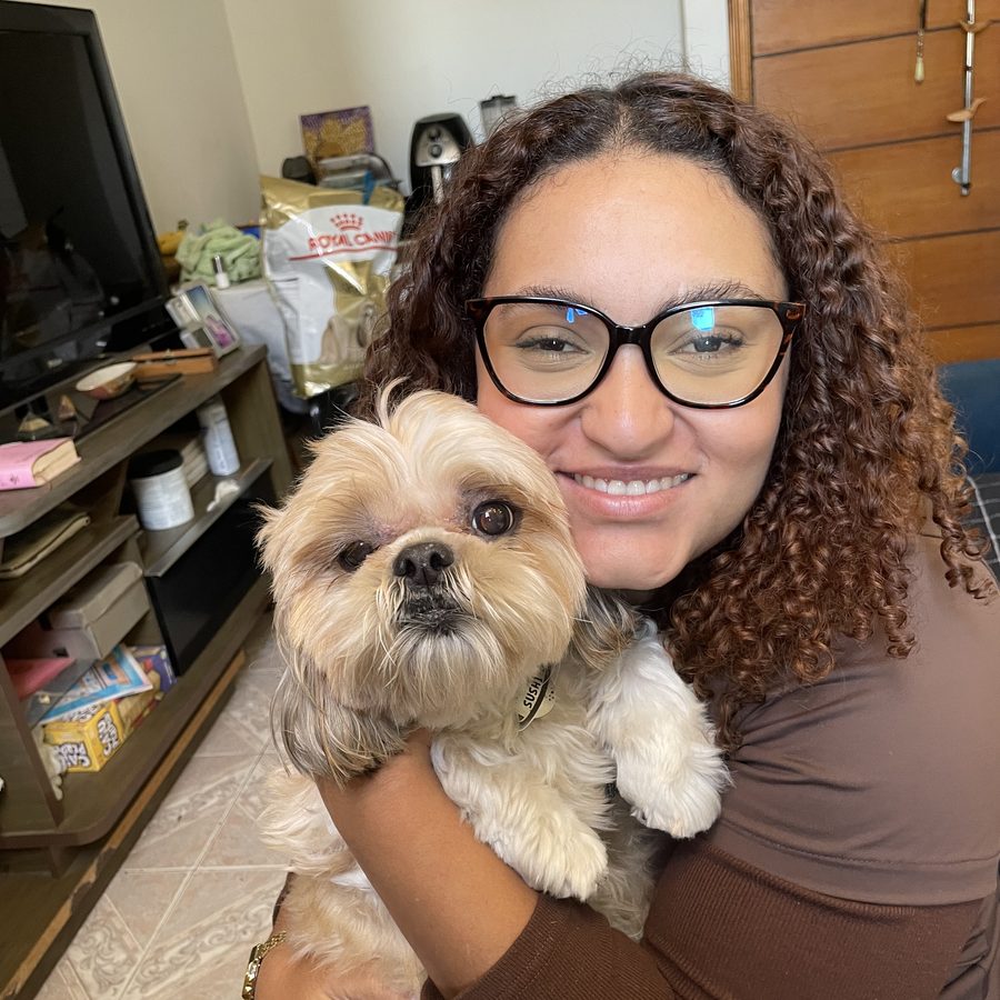 Dra. Mariana Helen abraçando um shih tzu durante consulta em casa