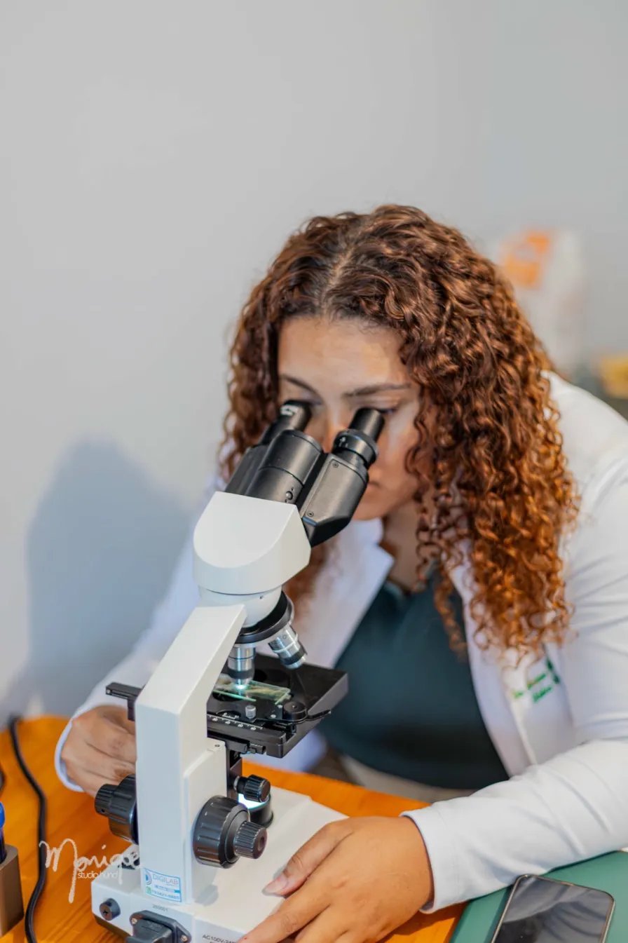 Dra. Mariana Helen analisando amostra no microscópio